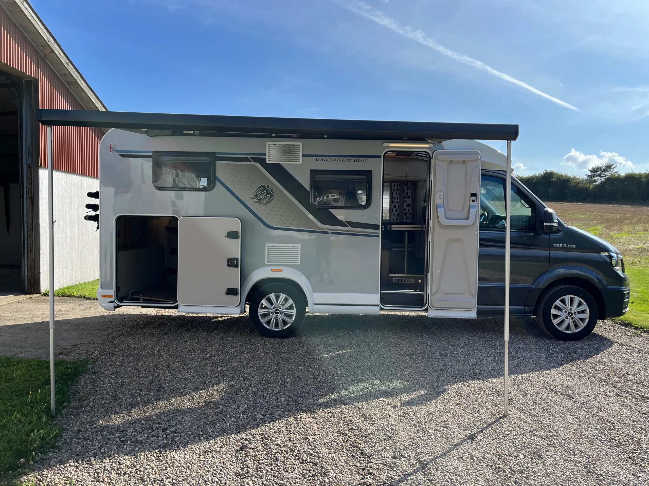 Autocamper med markise parkeret ved lade