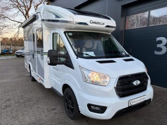 Hvid Chausson autocamper parkeret ved bygning